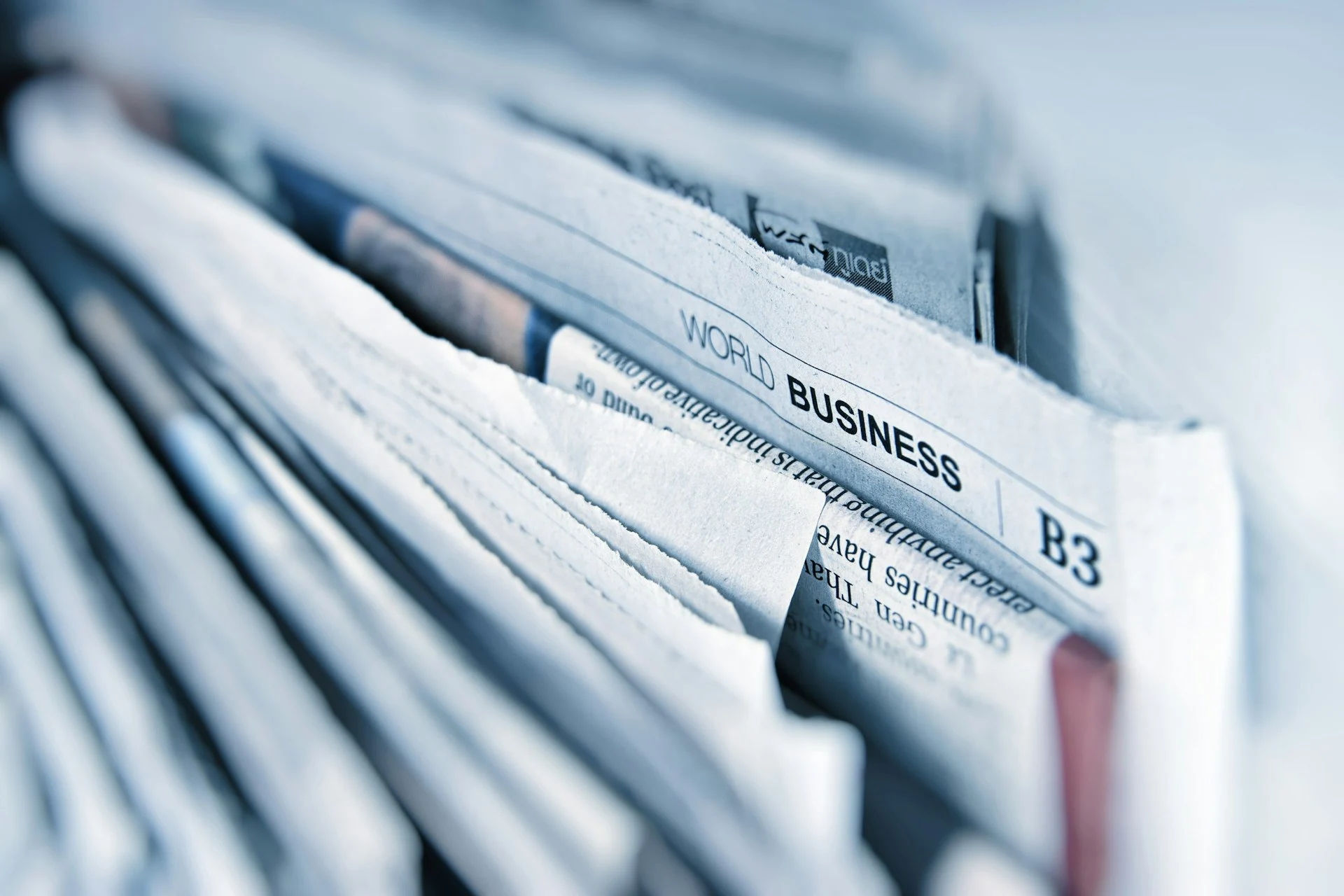 Stack of folded newspapers with a World Business section page showing